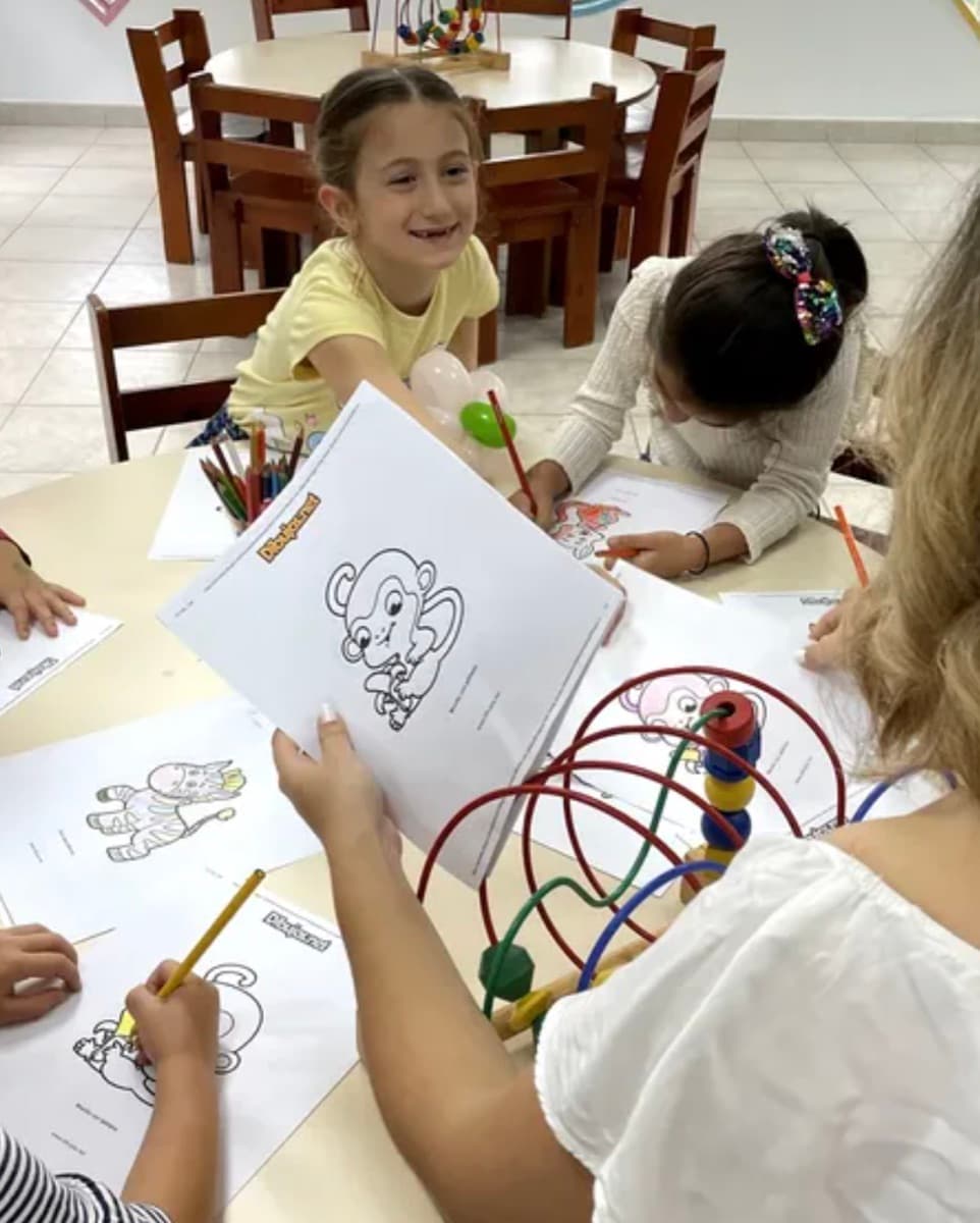 Niños coloreando juntos en la mesa de trabajo
