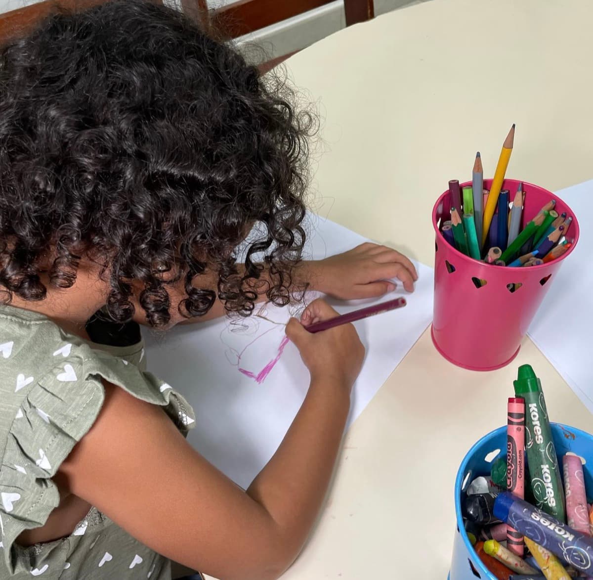 Niña dibuja con lápices de colores