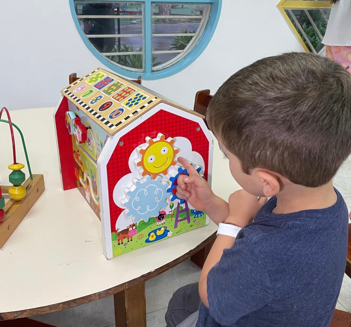 Niño juega con engranajes de madera